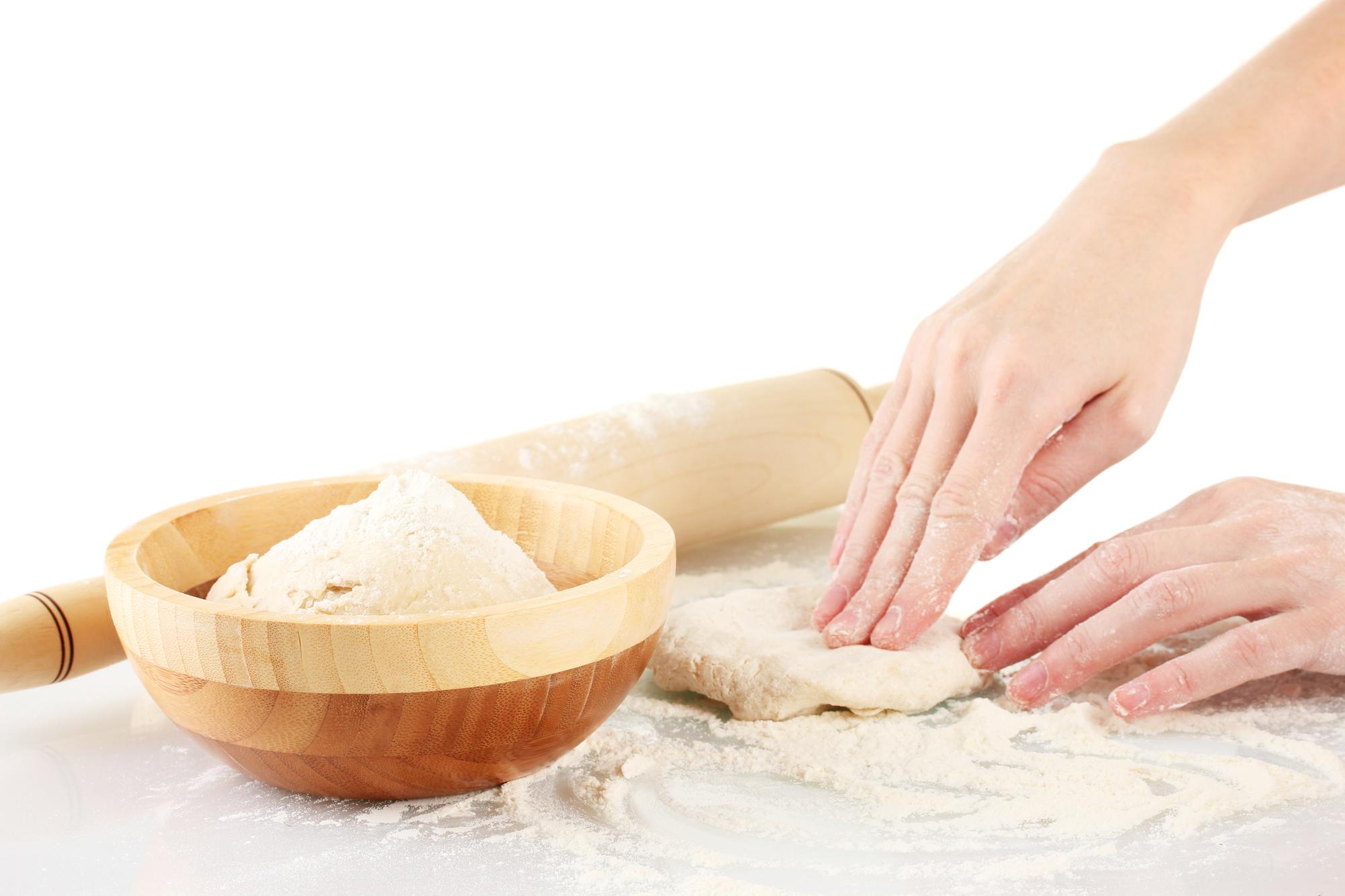 Close-up of hands kneading dough in warm kitchen light